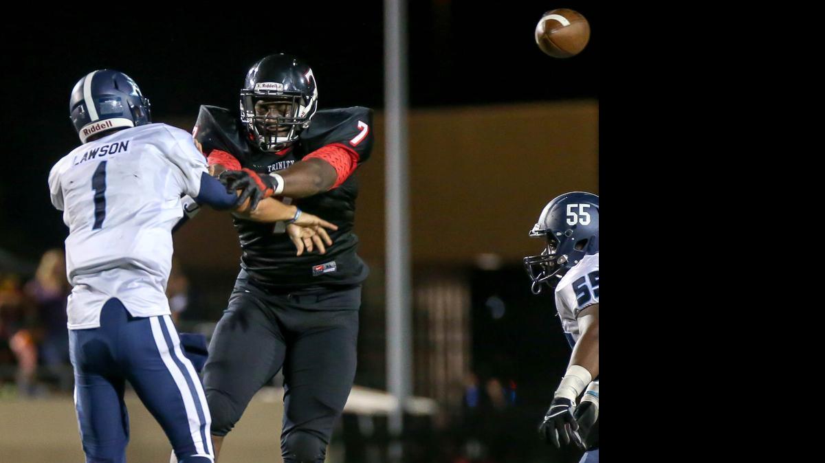 
Trinity's Chris Daniels (7) puts pressure on L.D. Bell quarterback Dominique Lawson as he gets the pass off last season in district play.

