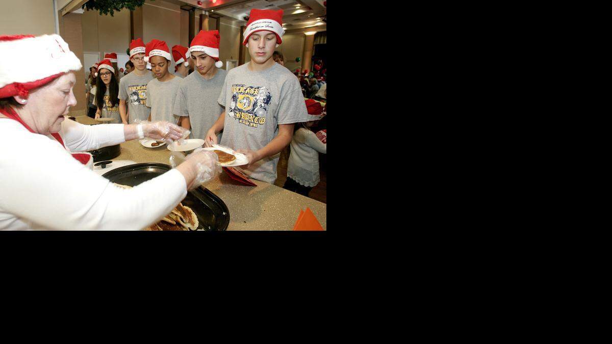 
Karen Bruton with the Colleyville Lions Club serves pancakes to Preston Jones, 13, fro Heritage Middle School during the Lions Club Breakfast with Santa fund raiser in Colleyville Saturday morning December 06, 2014. Breakfast included sausage, pancakes and breakfast drinks. More than 2000 pancakes were cooked. Over 1400 tickers were served. The Lions Club raised more than $31,000 last year with the event. 
