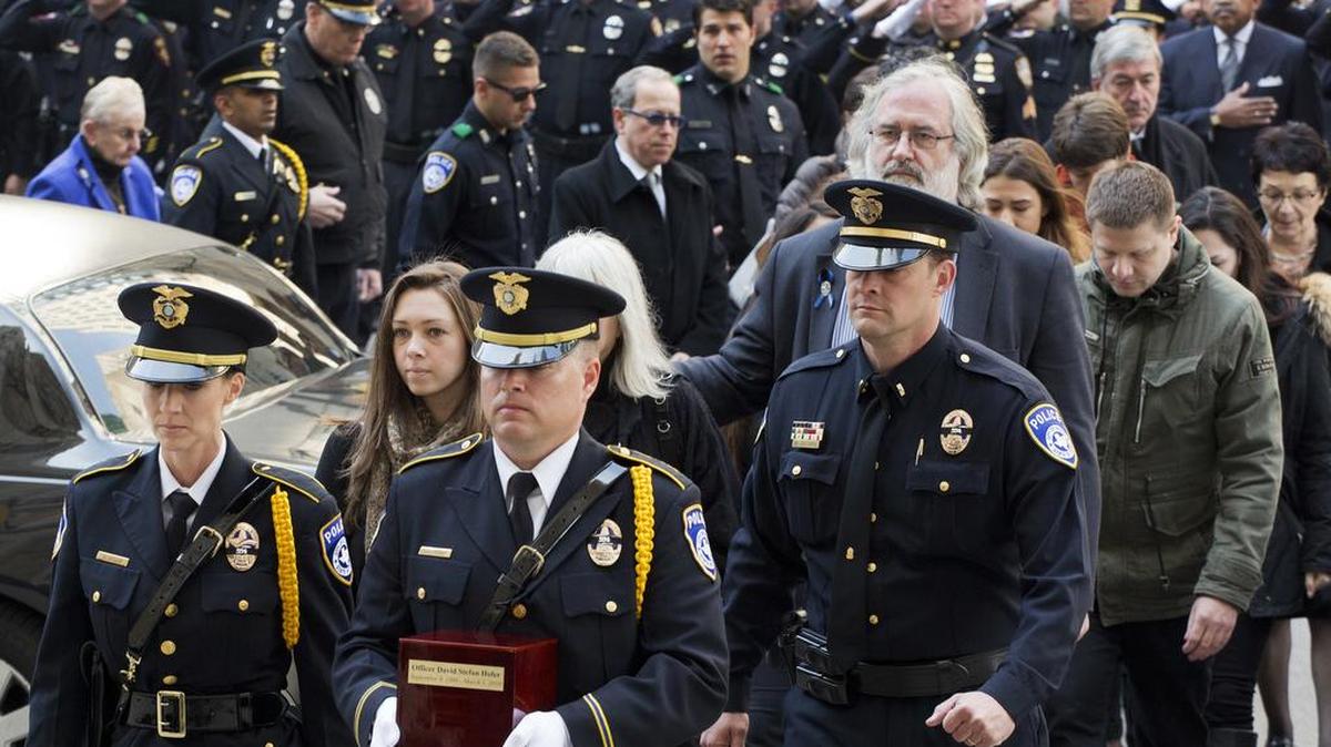 Marta Danylyk, at left behind police officers, and Helmut Hofer, tall, with gray hair and beard, arrive for the funeral Mass for Euless police Officer David Hofer on Monday, March 7, 2016, at St. Patrick's Cathedral in New York. Hofer was killed March 1. Hofer was a New York police officer before he and Danylyk, his fiancee, moved to North Texas. Helmut Hofer is the officer father.