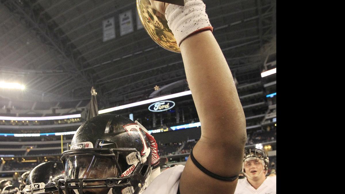 
Trinity quarterback Tyler Natee hoists the trophy last year after his team defeated Plano West at AT&T Stadium during the playoffs.
