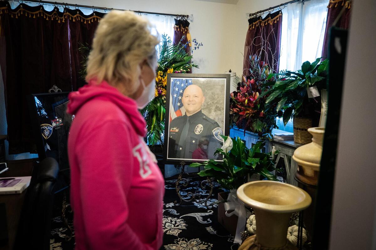 Heidi Stokes looks at a portrait of her husband Sgt. John Stokes who died suddenly Nov. 29, 2020.