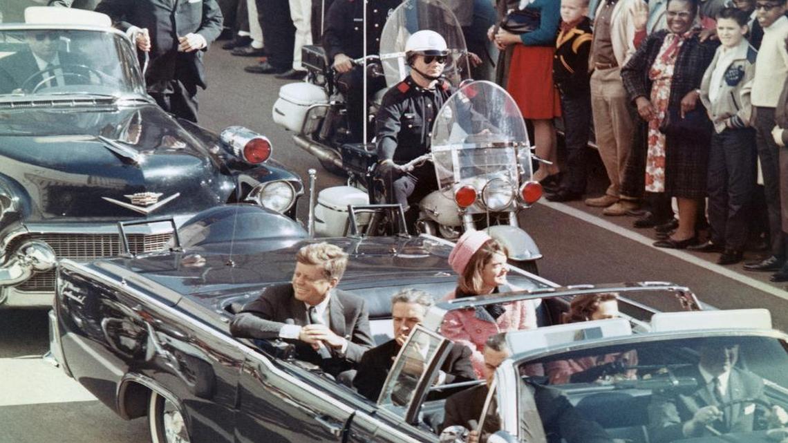 President and Mrs. John F. Kennedy smile at the crowds lining their motorcade route in Dallas, on Nov. 22, 1963. Minutes later the President was assassinated as his car passed through Dealey Plaza.