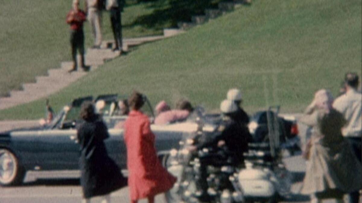 First Lady Jacqueline Kennedy cradles her husband, President John F. Kennedy, seconds after he was fatally shot. This frame grab image was made from a restored version of a film showing the assassination of President Kennedy in Dallas on Nov. 22, 1963.