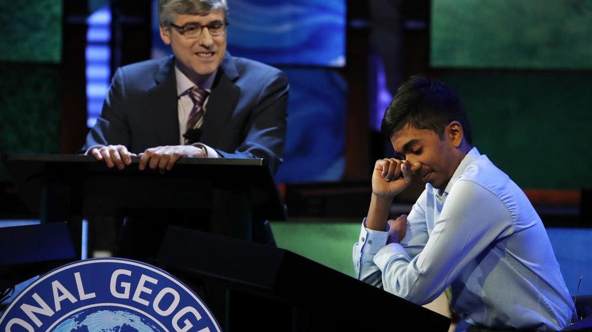 Host Mo Rocca watches at left as Pranay Varada, 14, of Irving reacts after winning the 2017 National Geographic Bee on Wednesday at the National Geographic Society in Washington.
