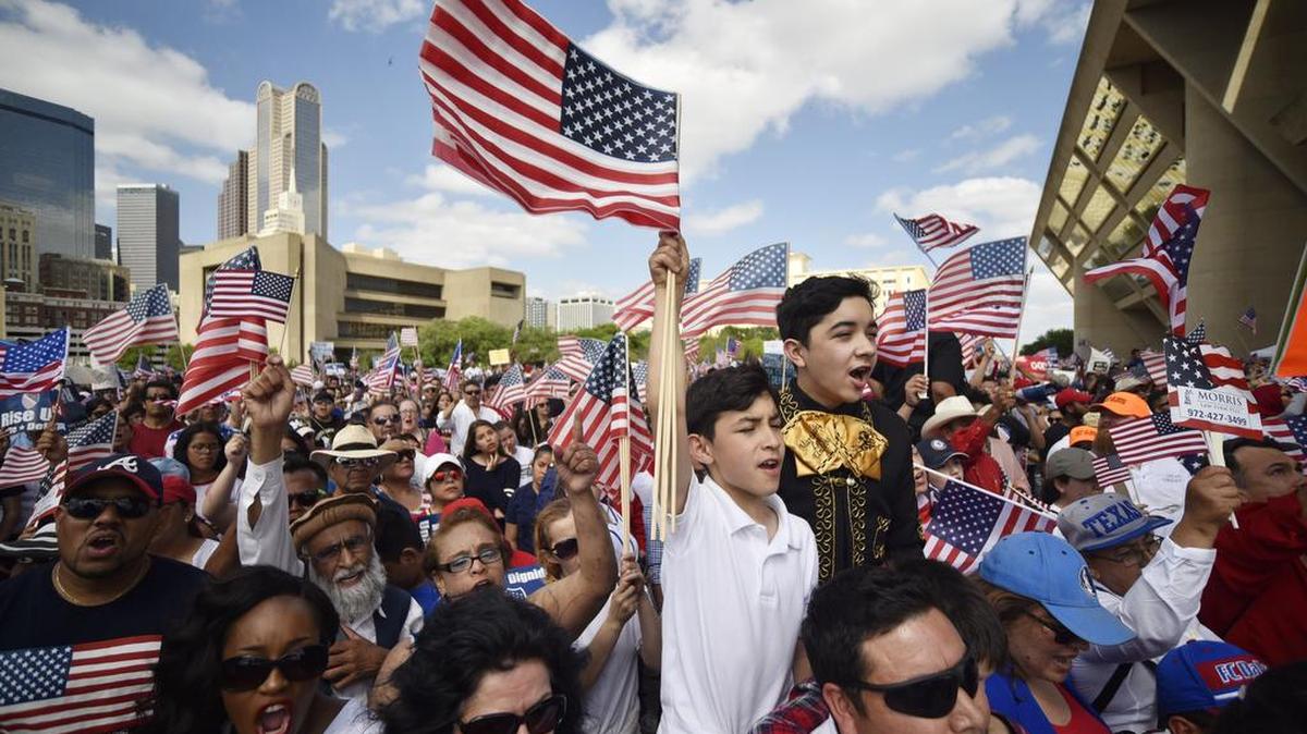Emiliano Reyes, 11, left, and his brother (dressed as a mariachi) Angel Reyes, 13, both of Dallas, cheer while listening to political leaders speak Sunday during the Mega March rally for immigration rights in downtown Dallas.