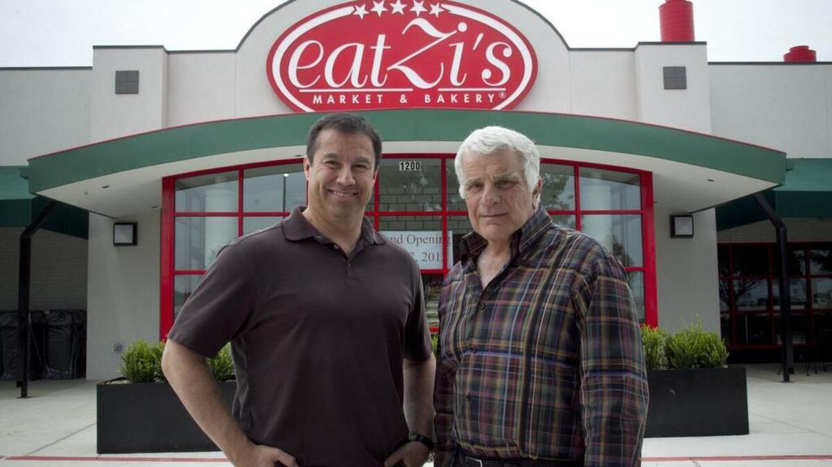 Phil Romano, right, founder of eatZi’s, is shown in a 2012 photo with Adam Romo Jr., chief executive officer at eatZi’s, outside the Grapevine location.