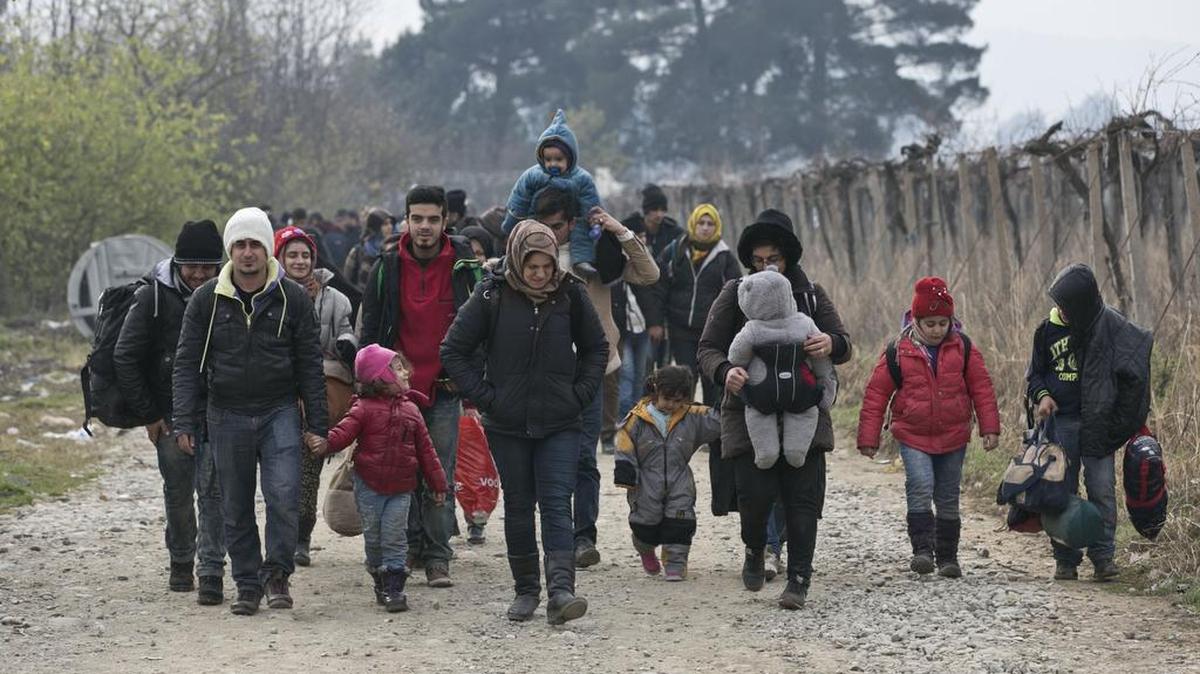Migrants and refugees walk towards a registration camp after entering Macedonia from Greece. Macedonia is allowing refugees from Afghanistan, Iraq and Syria to cross the border.