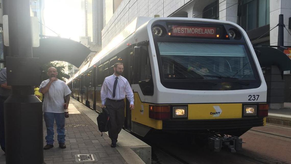 Commuters walk alongside a DART train in downtown Dallas Friday morning. Many regular riders apparently stayed away from downtown Dallas after Thursday night’s police ambush.