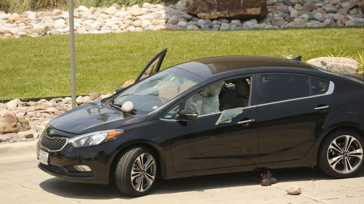 A large landscape stone lies against the windshield of a vehicle Friday after a domestic incident between a man and woman took place outside a baggage claim area at Dallas Love Field airport, resulting in an officer firing at the man.