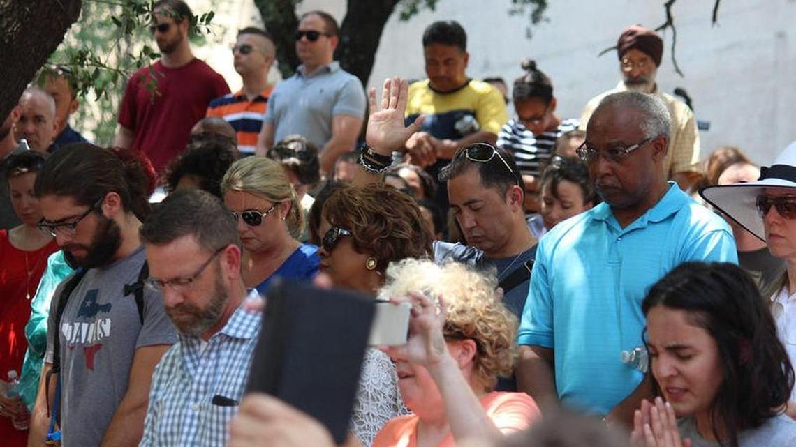 People bow their heads during an interfaith prayer service at Thanks-Giving Square in Dallas on July 8, 2016.