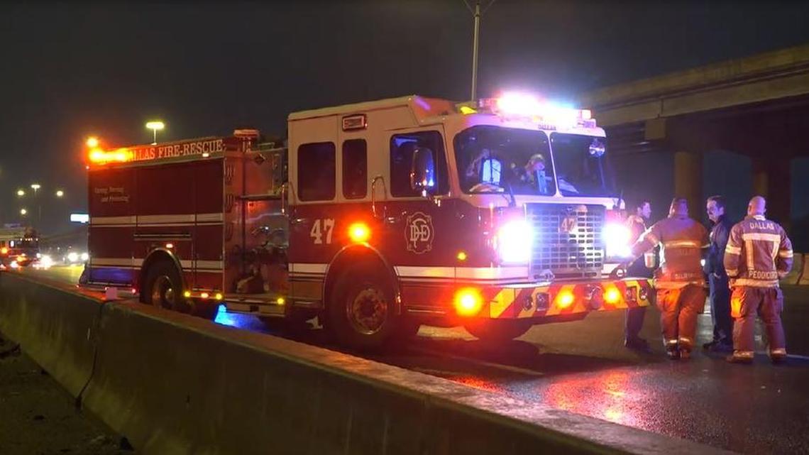 Two people were injured Wednesday after a vehicle struck a Dallas fire engine stationed at the scene of a major accident, officials say.