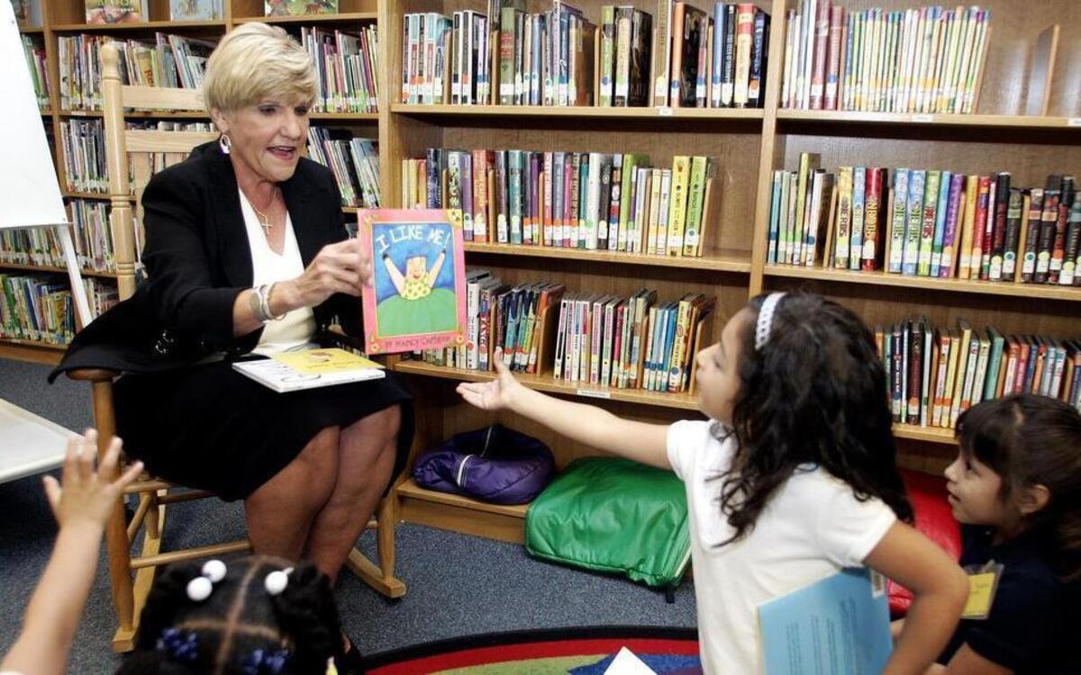 Aliyah Burdos, 5, receives a copy of I Like Me from Mayor Betsy Price during the announcement of the Fort Worth literacy project at Oakhurst Elementary school in Fort Worth Monday morning.