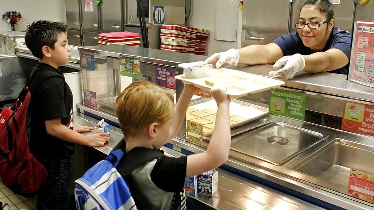 
Cafeteria server Maria Arreola passes out trays to children during the first day of school at Dove Elementary School in Grapevine in this 2014 file photo. Many area districts are adding locally grown fare to the menus for school year that starts Monday for most.
