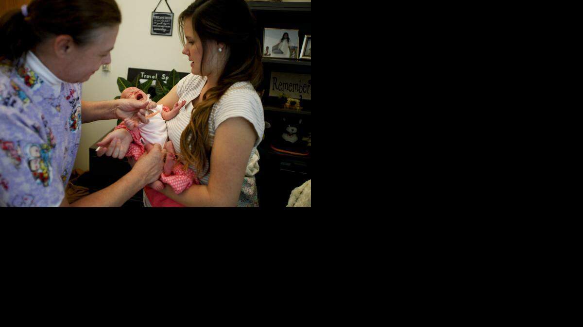
Before traveling abroad, residents are urged to make sure their measles vaccinations are current. Here. nurse Bonnie Hardy gives McCall Messick a measles vaccination while Messick's mother, Amy, holds her at the Utah County Health Department in Provo on Jan. 7, 2015. 
