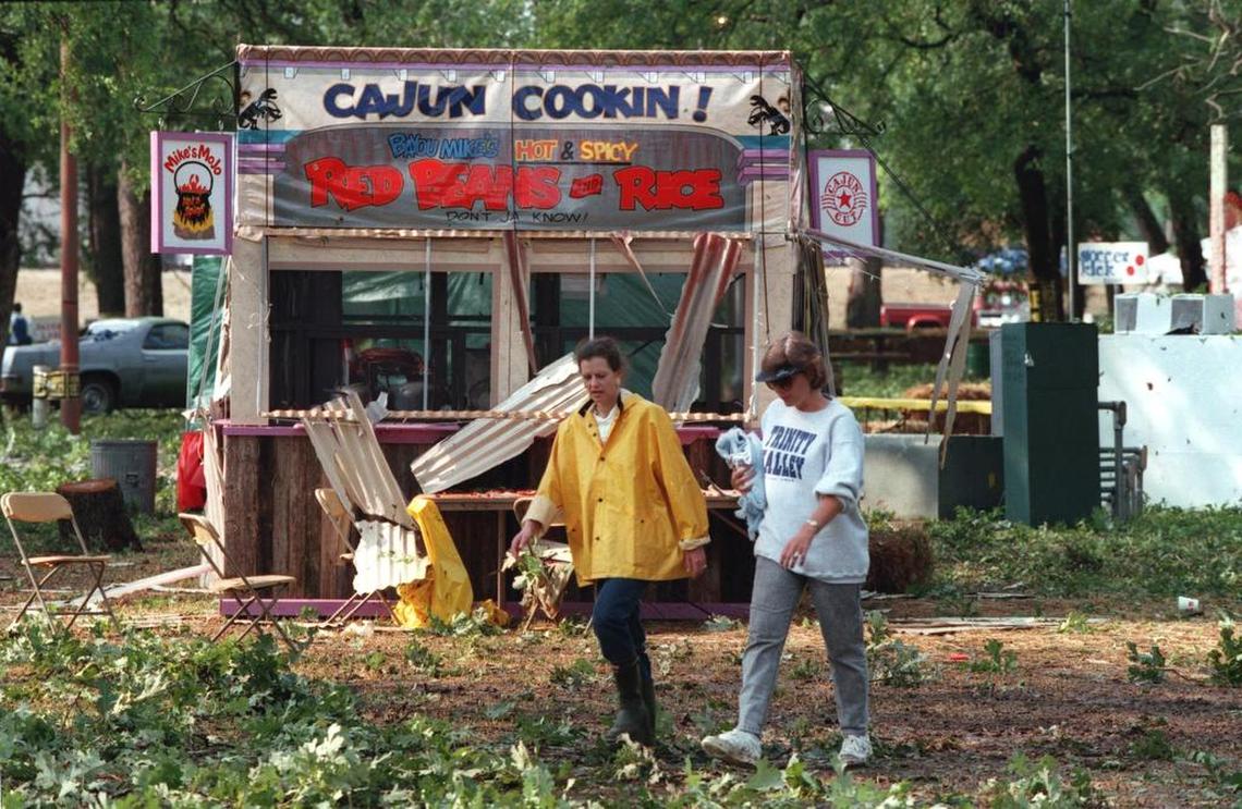 The day after the May 5, 1995, hailstorm, Mayfest volunteers Charlotte Cummings and Judy Bohnsack walked past a damaged food booth in Trinity Park.