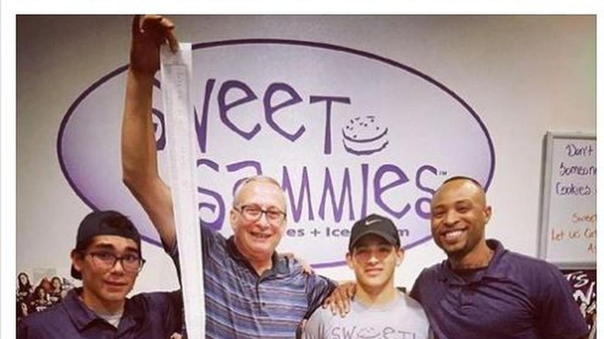 “Mr. Gary” holding the 7-foot receipt after buying $1,300 worth of ice cream for Sweet Sammies guests Saturday night.