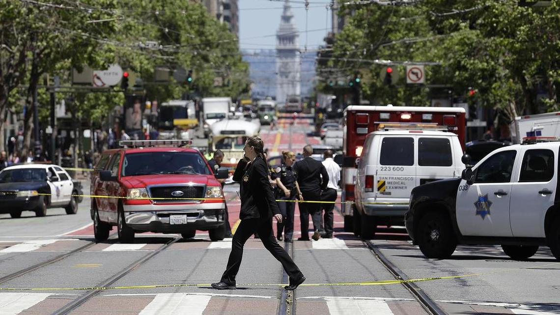 Police officers and officials patrol along Market Street after a shooting Wednesday in San Francisco.