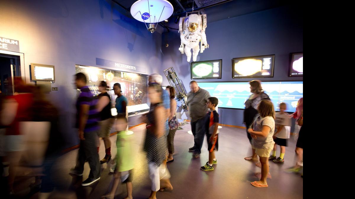 
Visitors file in to hear Ken Ruffin, president of the National Space Society of North Texas, talk about Pluto in the Noble Planetarium at the Fort Worth Museum of Science and History on Tuesday, July 14, 2015. 
