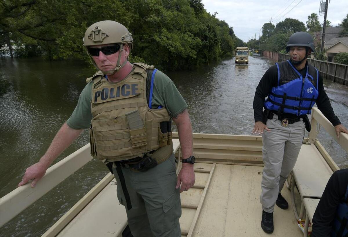 Grand Prairie police Lt. Anthony Hogan, left, and Sgt. James Edwards paired up with members of the Texas Army National Guard to rescue stranded residents of west Houston.