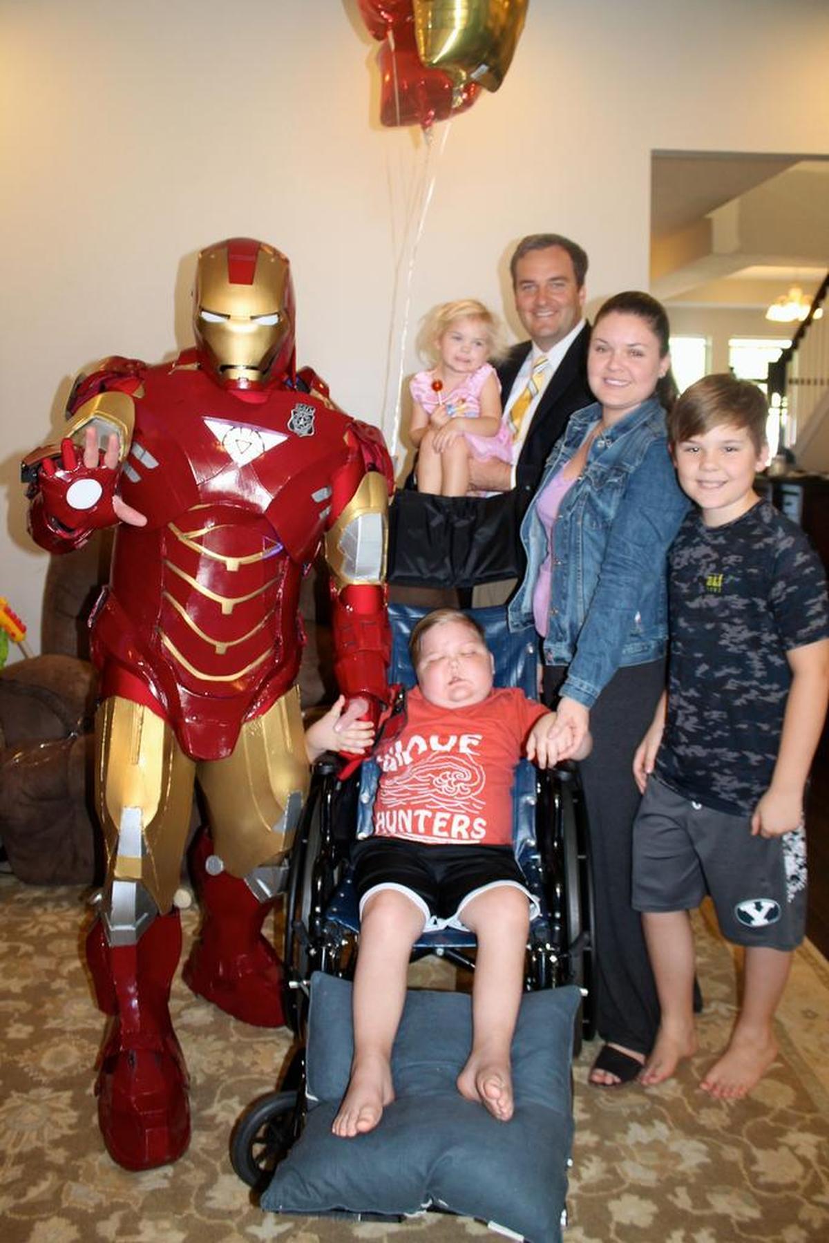 Fort Worth police Officer Damon Cole as Iron Man visits Cole St. Clair, center, and his family in Florida in a file photo.