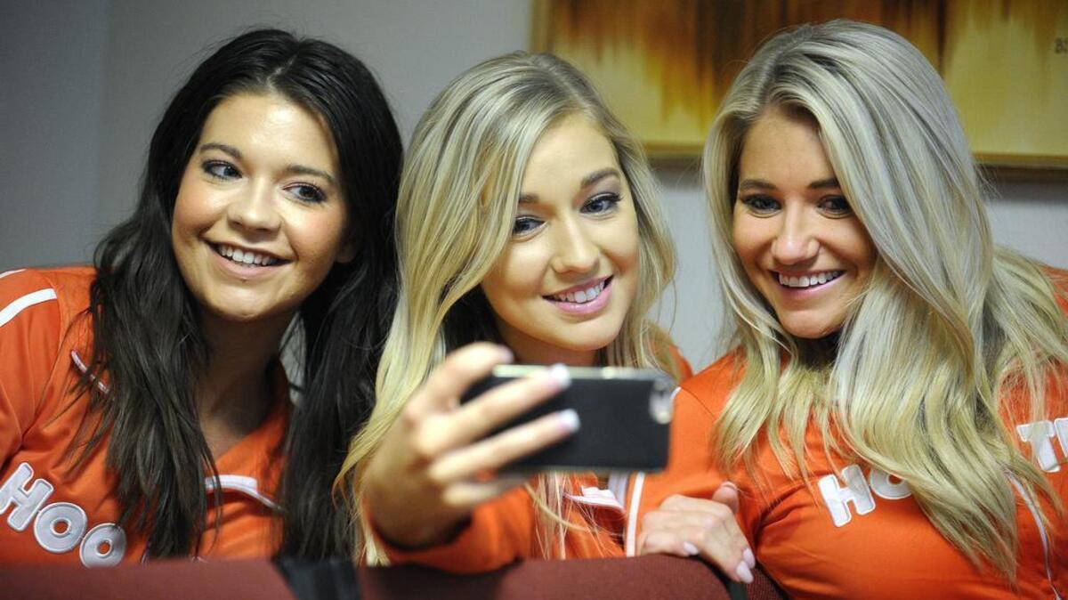 Three Hooters waitresses take a selfie during a break in the TABC hearing Tuesday about the restaurant’s application for a liquor license. The Downtown Fort Worth Neighborhood Committee is opposing the license.