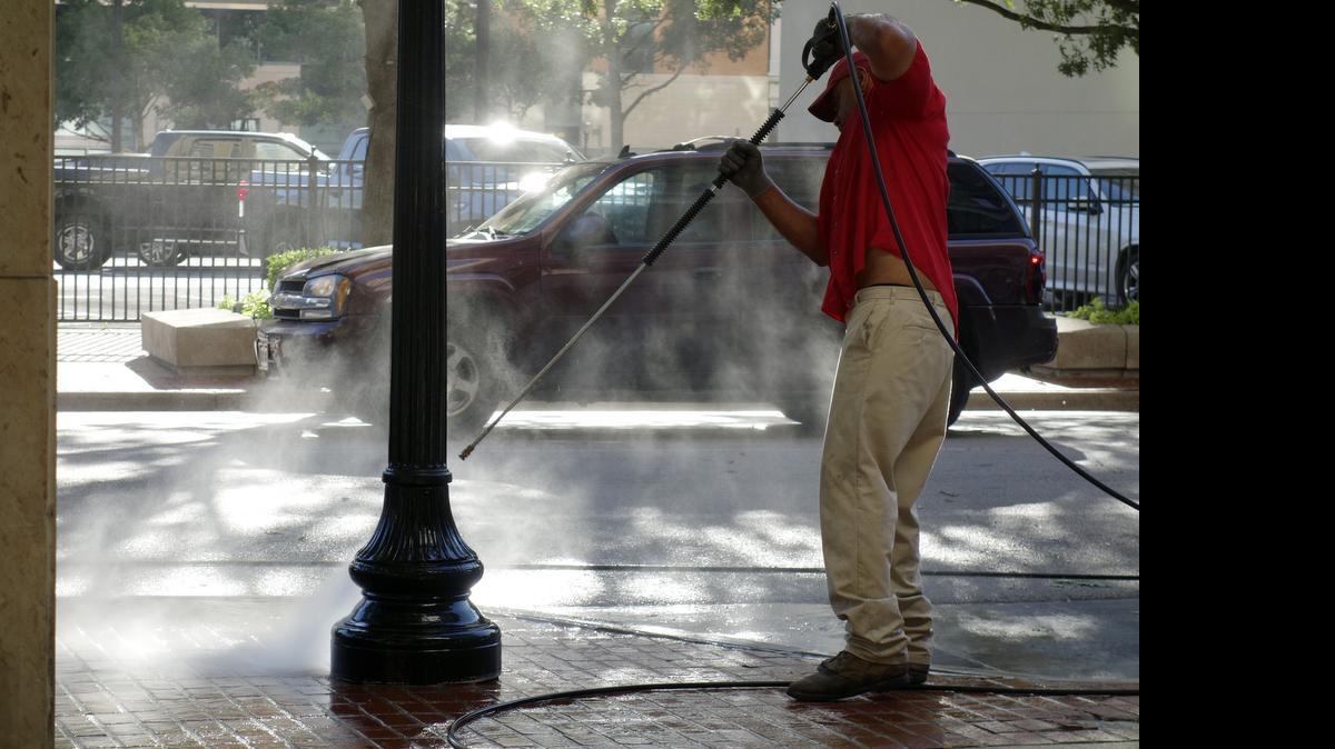 
Byron Lewis of Downtown Fort Worth Inc. steam cleans landscaping on Throckmorton Street in downtown. The day will get steamier, with temperatures approaching 100 degrees for the first time this year.
