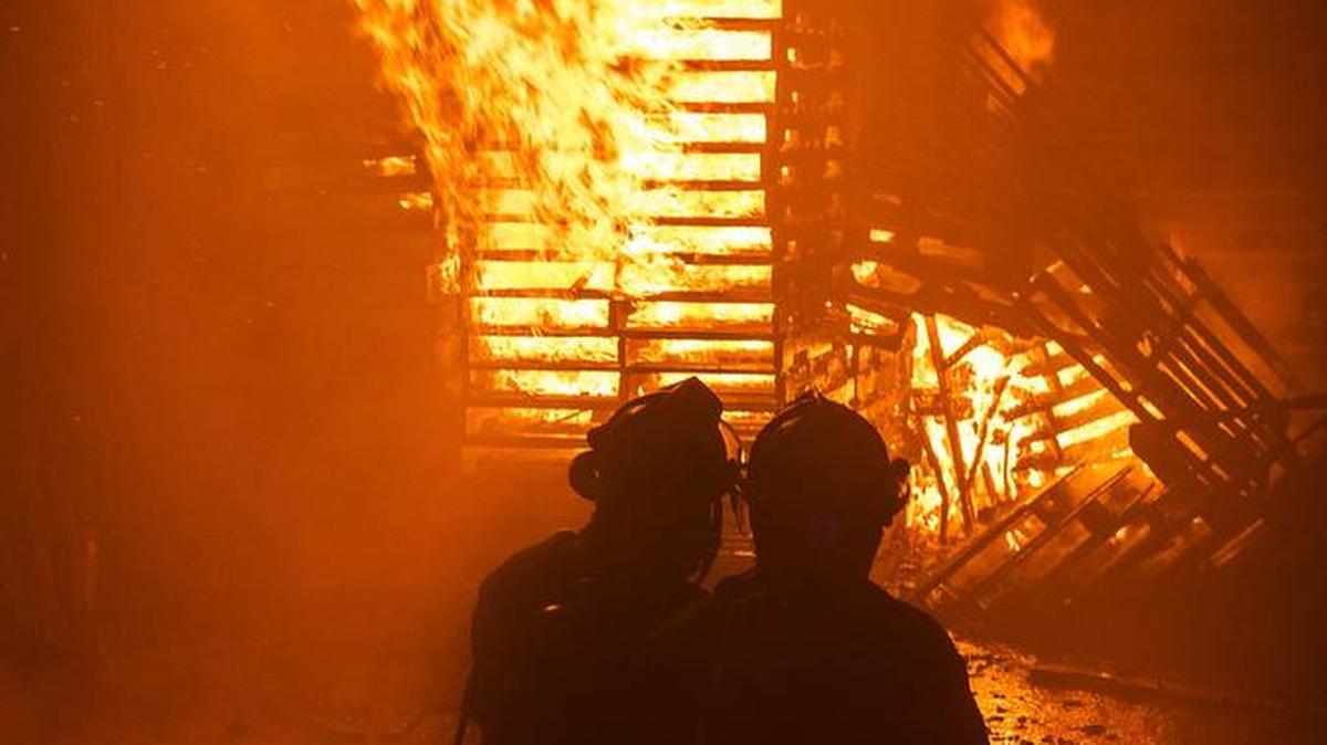 Fort Worth firefighters confront a blazing tower of pallets at the JC Pallet Co. Thursday night just south of the Fort Worth Stockyards. The fire damaged or destroyed more than 2,000 pallets and also damaged company machinery. There were no injuries and arson investigators were trying to determine the cause of the blaze.