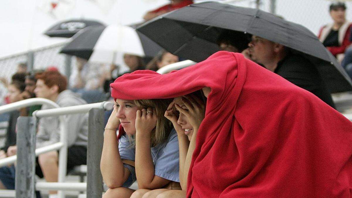 
Haley Parrish, Haley Allen and Callie Hutchinson take cover from a downpour Friday evening at a baseball game between Timberview and Legacy high schools. The game was stopped because of the weather in the top of the fourth inning. The game is to resume Saturday at 2 p.m.
