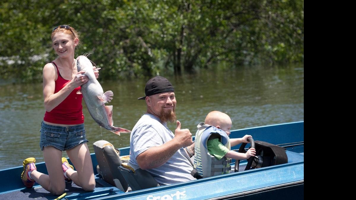 
Stephanie and Mitch Morrison caught an 11-lb. catfish Sunday and their son Colby got some experience at the wheel of the boat. Boaters and fishermen flocked to Benbrook Lake, the only local lake whose marina is open to boats.
