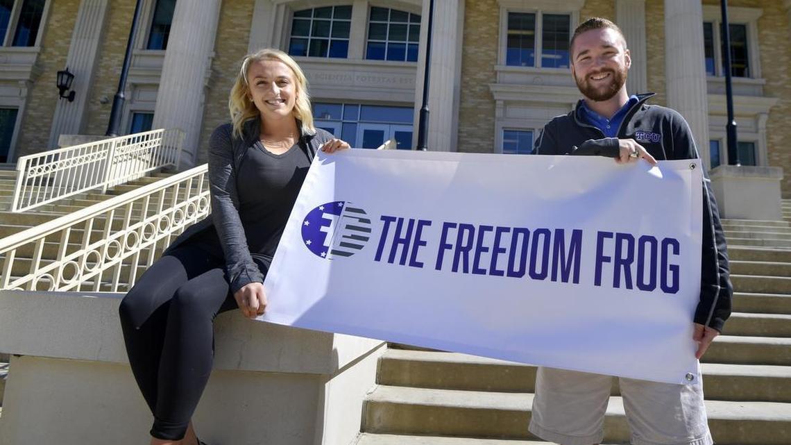 TCU Republicans Annabel Scott and Matt VanHyfte hold a banner for conservative newspaper Freedom Frog on campus.