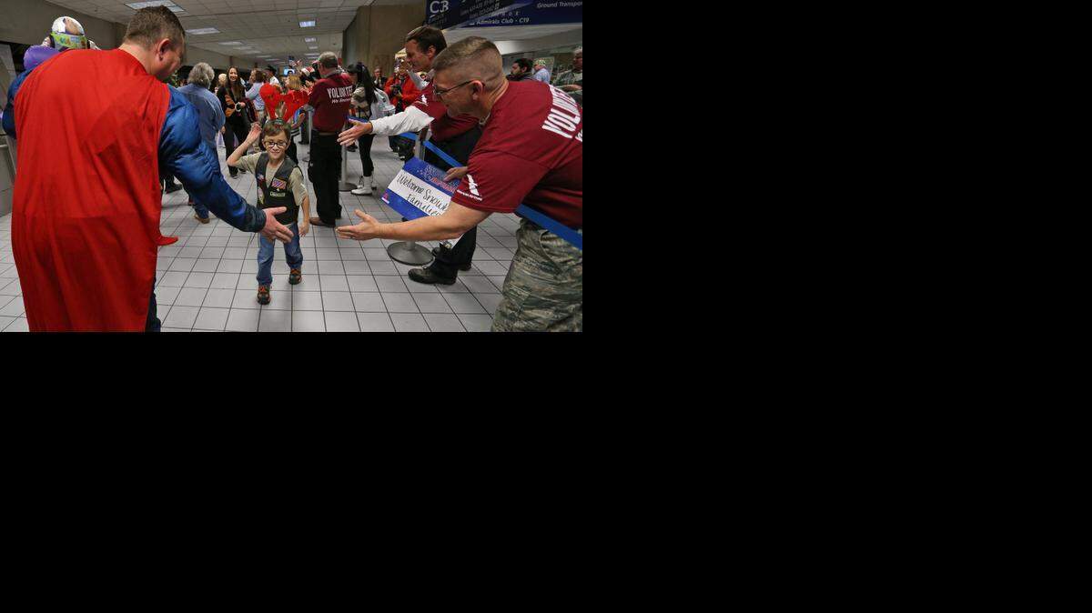 
Jackson Thomas, 8, greets volunteers at DFW Airport Thursday. His father, Ryan J. Thomas, was killed while serving in the Air Force. Jackson was arriving for the holiday Snowball Express weekend. 
