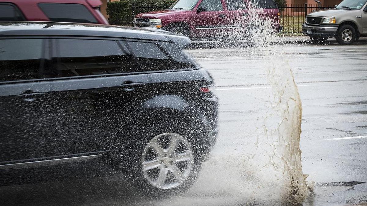 Water flies as a vehicle hits a pothole in the 3000 block of Harry Hines Boulevard in March.
