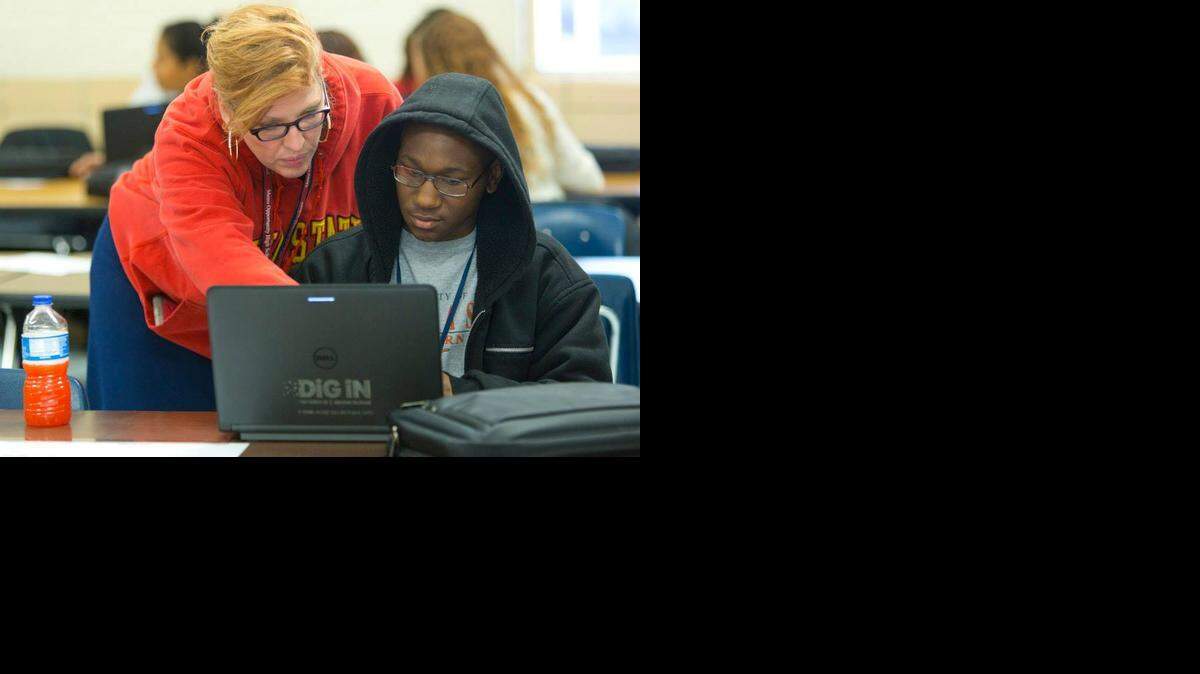 
An educator at Eastern Hills High School helps a student log in to his new laptop on Saturday as part of the district's laptop rental program, "DiG iN."
