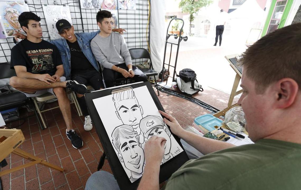 Artist Dan McMelan sketches friends Stephen Gonzalez, Brandon Vasquez and Jose Godinez on Main Street. The 2017 Main St. Arts Festival began in downtown Fort Worth Thursday.