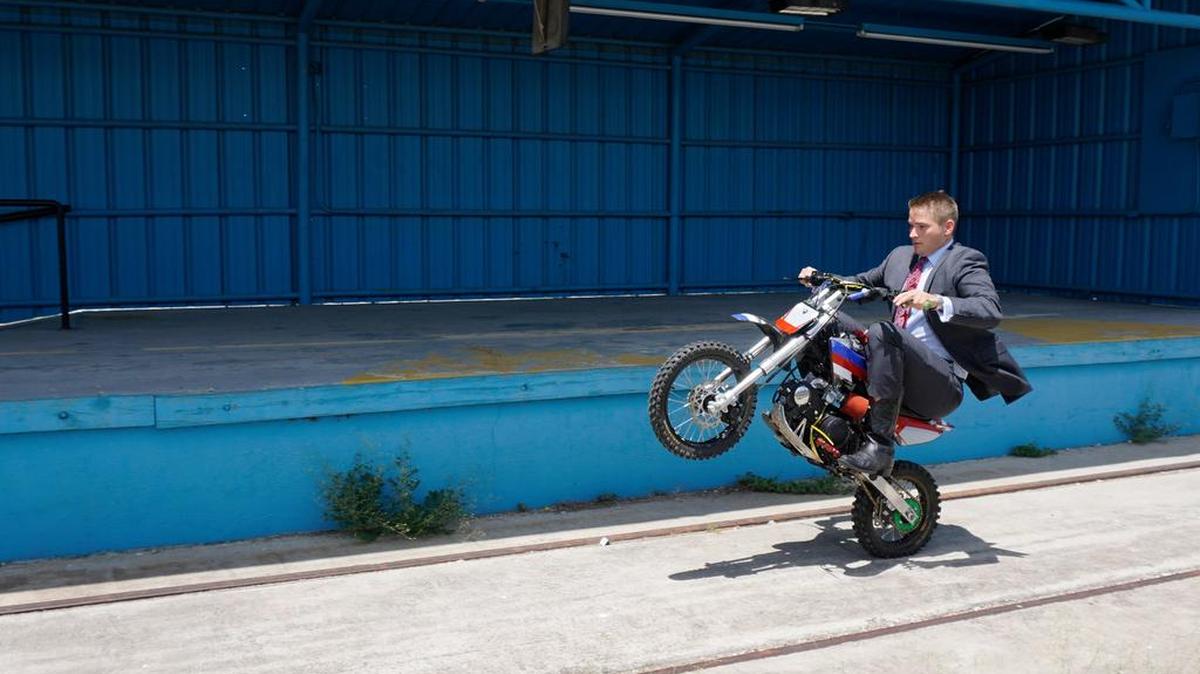 Attorney Bryan Wilson, who advertises himself as “the Texas Law Hawk” doing a wheelie on his mini bike near downtown Fort Worth