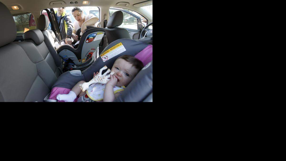 
Jeremiah Salmon of Safe Kids Tarrant County helps Kayla McKeehan of Burleson properly install a car seat and buckle her children in correctly. 
