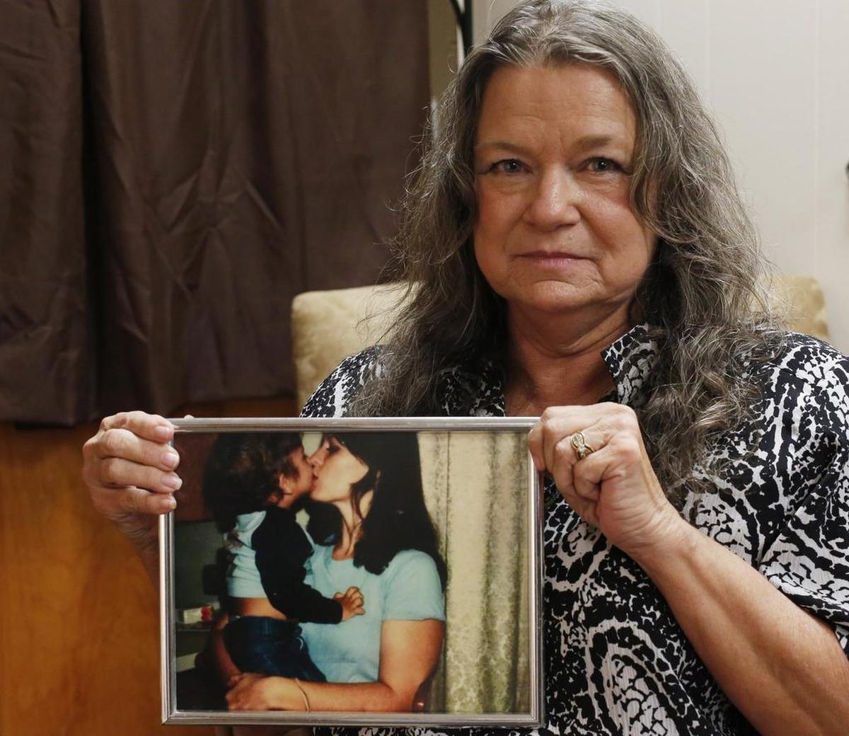 Jan Tunnel Webster holds a photo of her deceased sister, Cheryl Springfield, who was found slain on Christmas morning 1980.