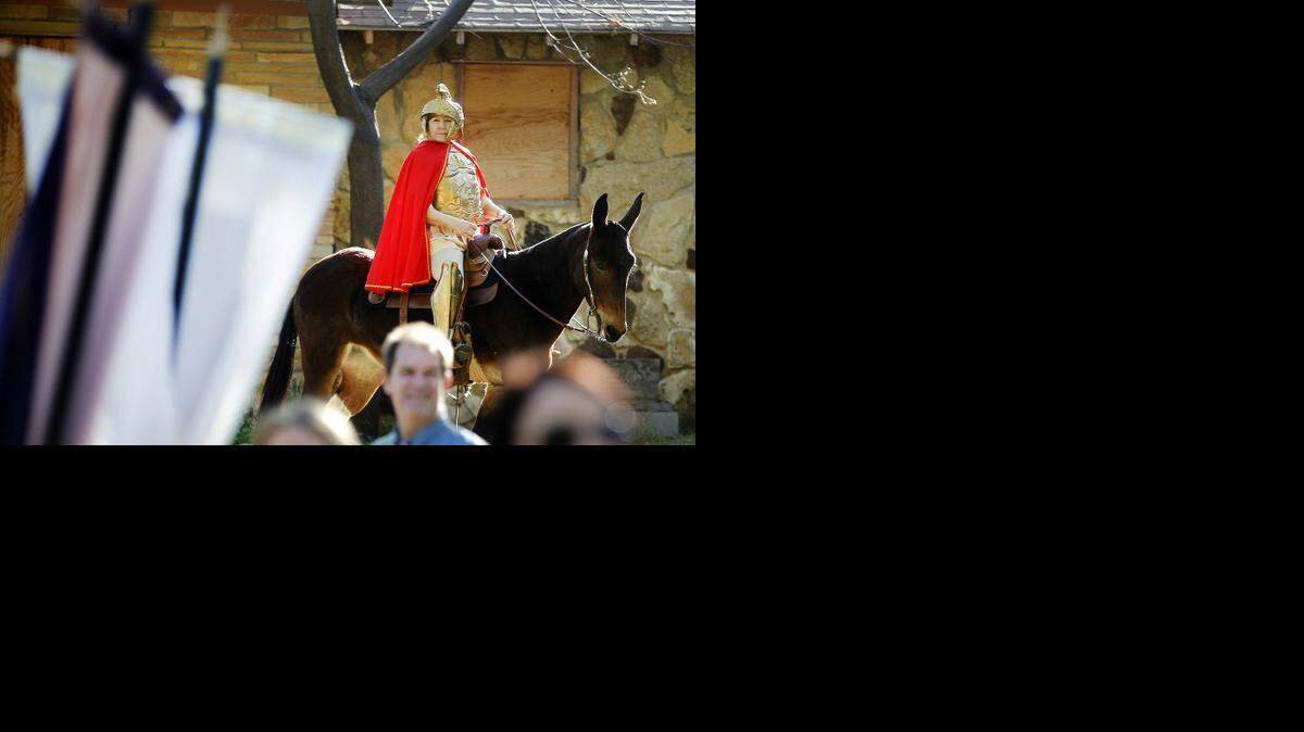 
Robin Thomas portrays a Roman soldier, with her mule "Leggs" during services at the 60th annual Palm Sunday Procession and Mass at St. Timothy Church in Fort Worth on Sunday, March 29, 2015. 
