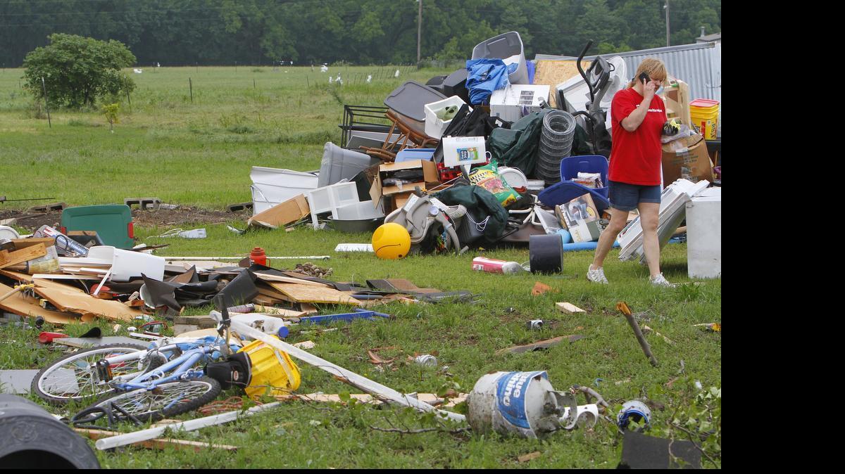 
Neighbors and friends help clean up Friday morning after a tornado Thursday night damaged Greg and Nanette Pickinpaugh's home and travel trailer north of New Fairview.
