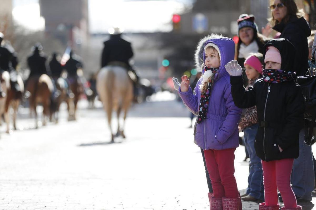 Twin sisters Theresa, left, and Katherine Thompson, 6, wave to participants during the Fort Worth Stock Show and Rodeo All Western Parade on Saturday.