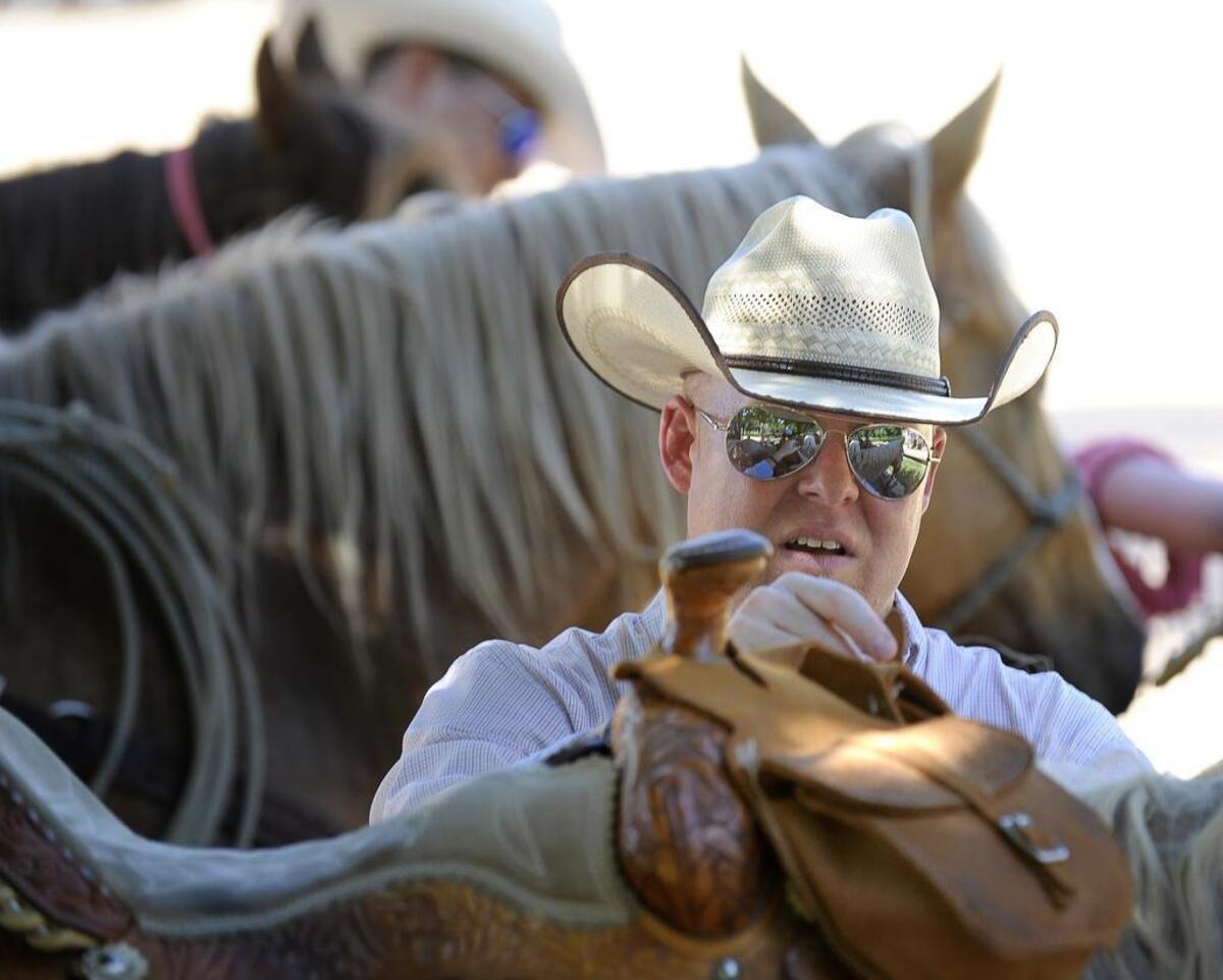 Chris Campbell ties his horse to a fence along the Trinity Trail in Fort Worth.