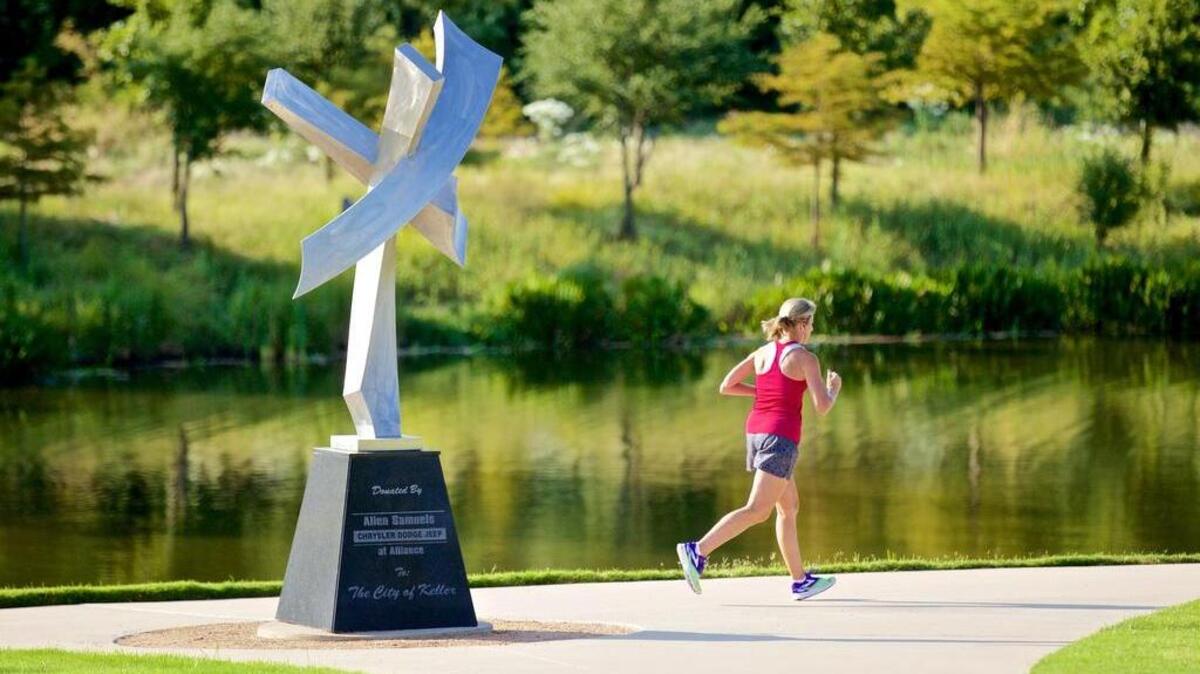 
A jogger runs by “Comet Dancing” in a recreational trail in Keller on Tuesday, Sept. 1, 2015. 
