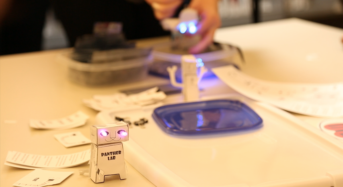 Paper robot with purple LED lights illuminating its eyes