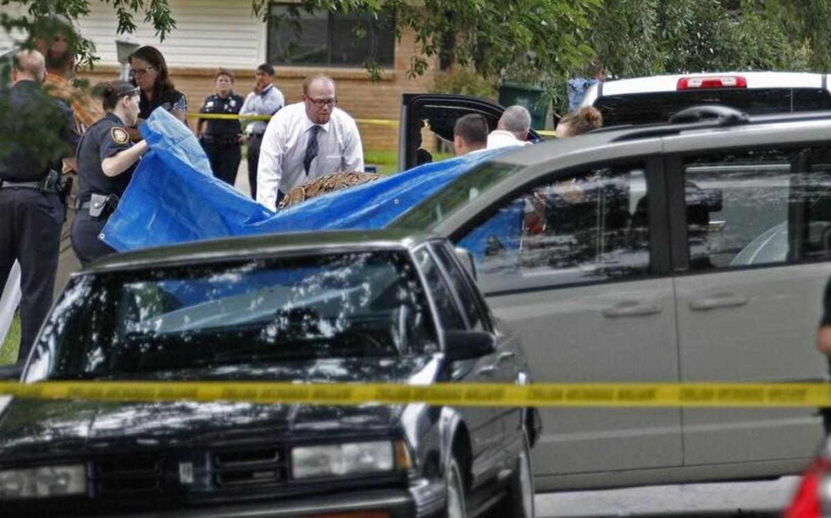 
Fort Worth police hold up tarps as staff of the Tarrant County medical examiner’s office remove the body of a pickup driver fatally shot by a police officer. The shooting was in the 6000 block of Wheaton Drive in Wedgwood.
