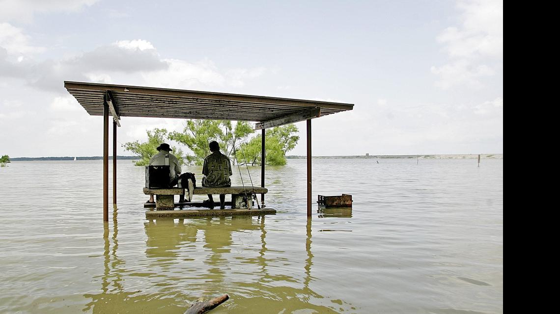 
Gabe Carrion and son Roman waded about 40 to 50 feet to a picnic table to fish at Katies Woods Park at Lake Grapevine Wednesday afternoon. Many area lakes are facing high water for the Memorial Day weekend.
