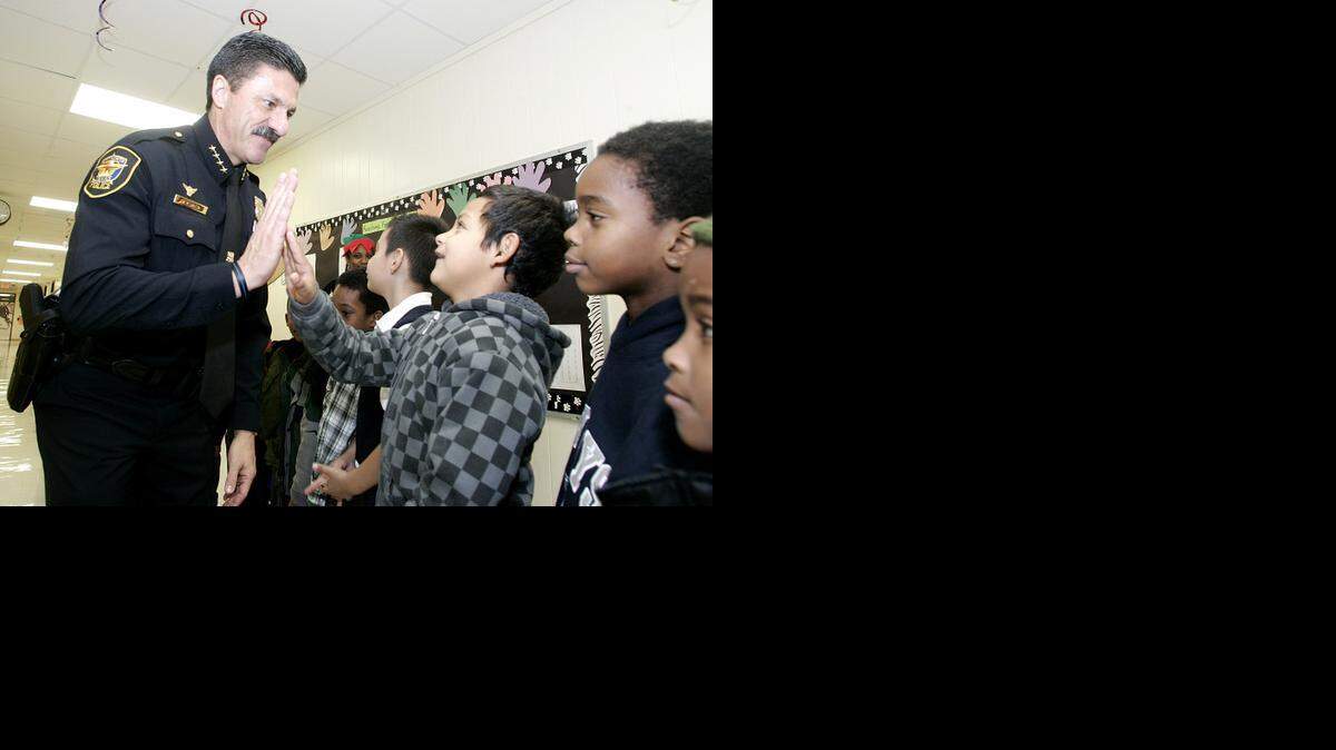 
Fort Worth Police Chief Jeff Halstead high-fives Angel Ontiveros-Moreno, 7, in the hallway as students received gifts at Van Zandt-Guinn Elementary School Dec. 19, 2014. All students received a Christmas gift that Friday morning. 
