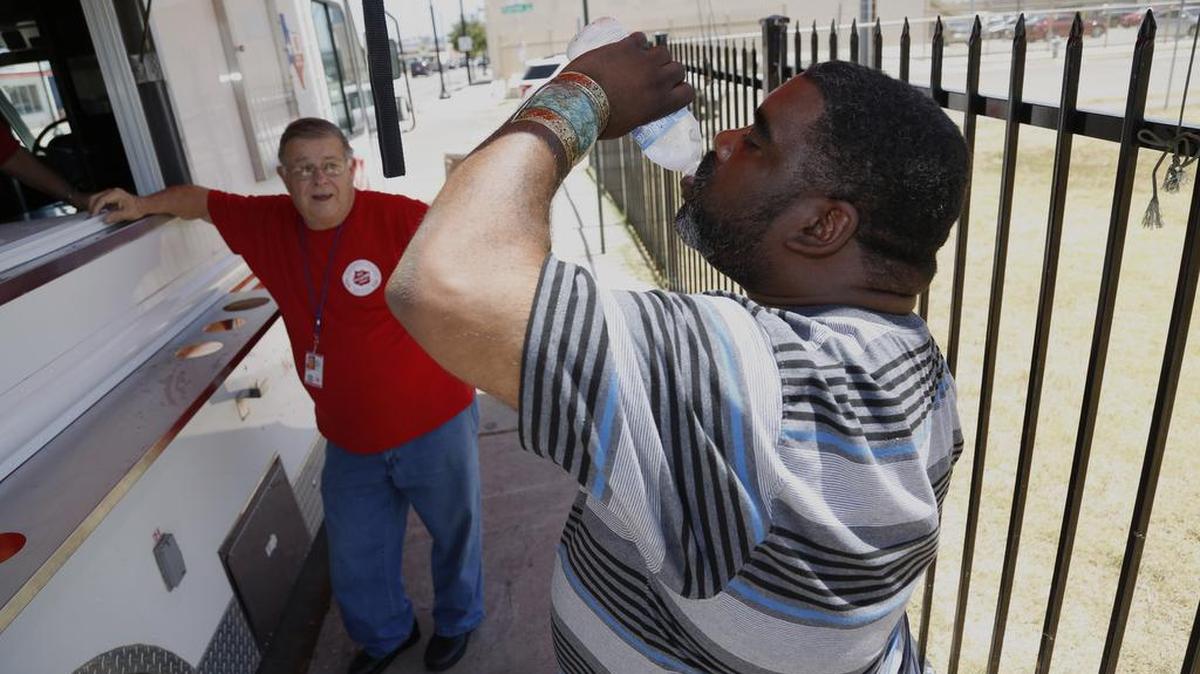 
On Monday, Salvation Army volunteer Frank Calvert watches as David Perry enjoys some of the free water from The Salvation Army Mobile Disaster Food Truck. It wasn’t quite as hot on Tuesday and no 100-degree temperatures are predicted for the rest of the week. 
