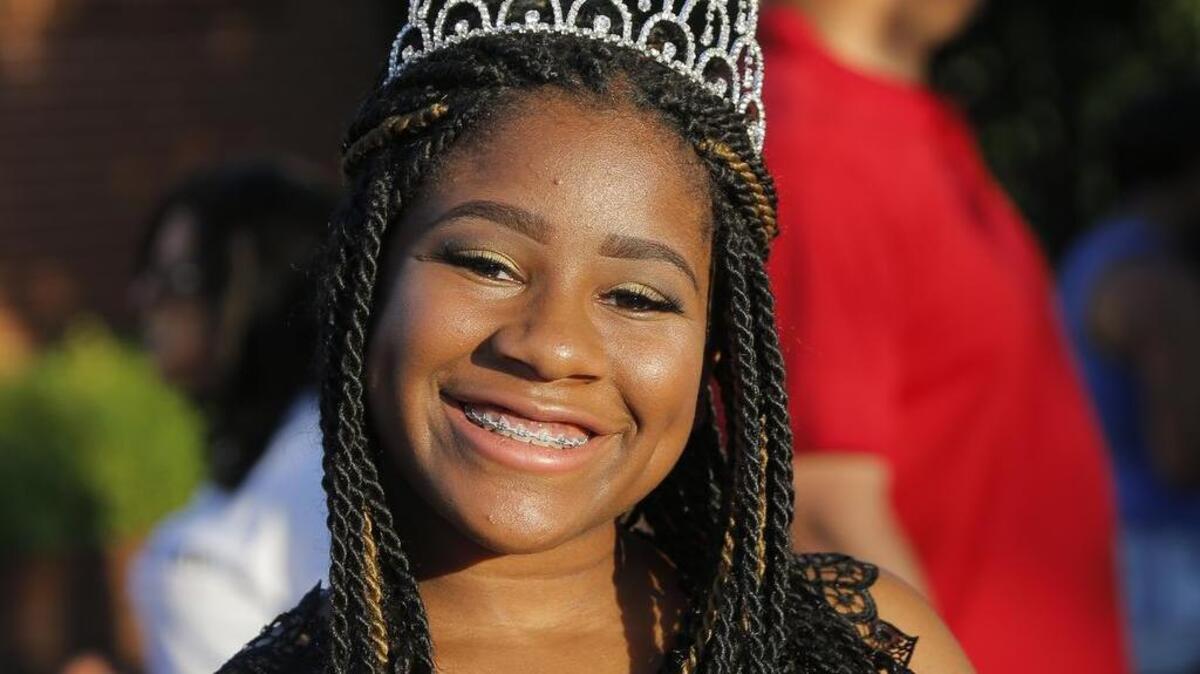 Mia Smith Chafer, who is Miss Federated Women’s Club, smiles after riding in the Juneteenth Parade on Evans Avenue, Friday, June 17, 2016.