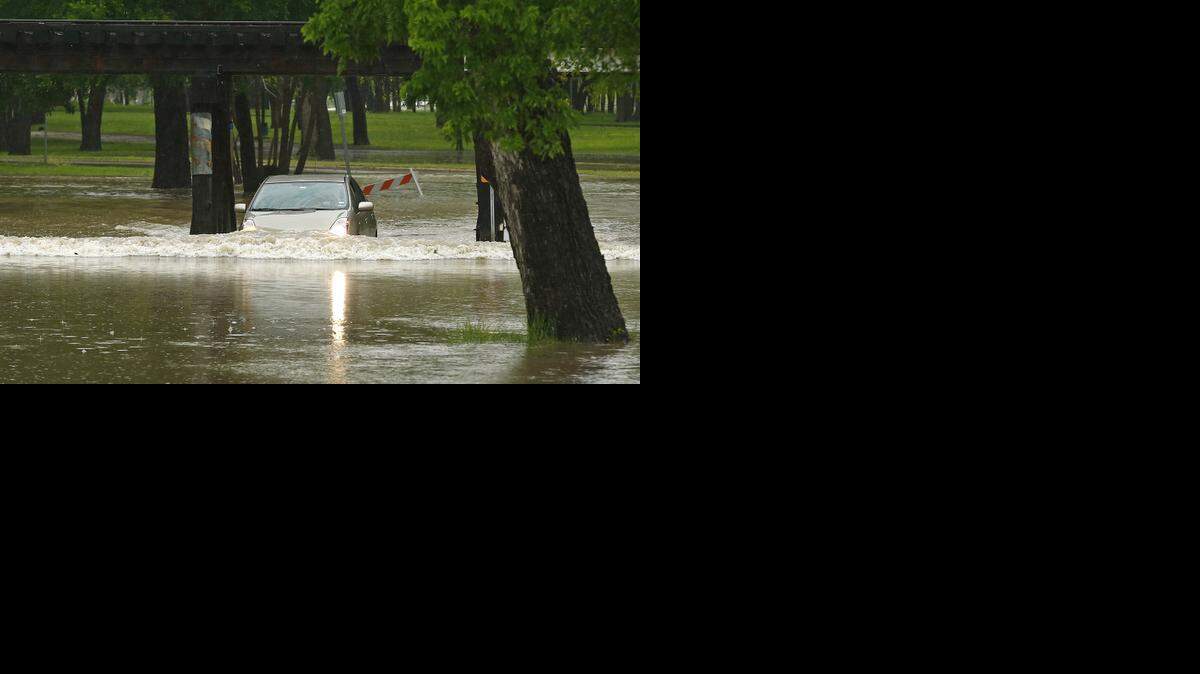 
A driver somehow successfully drives through low water in Trinity Park. 
