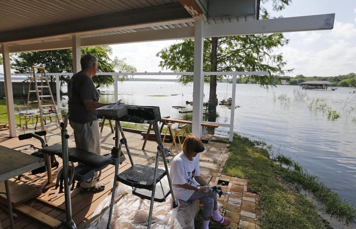 Steve and Kay Bischoff work on an awning for their deck despite flooding concerns this spring on Lake Worth and other area lakes.